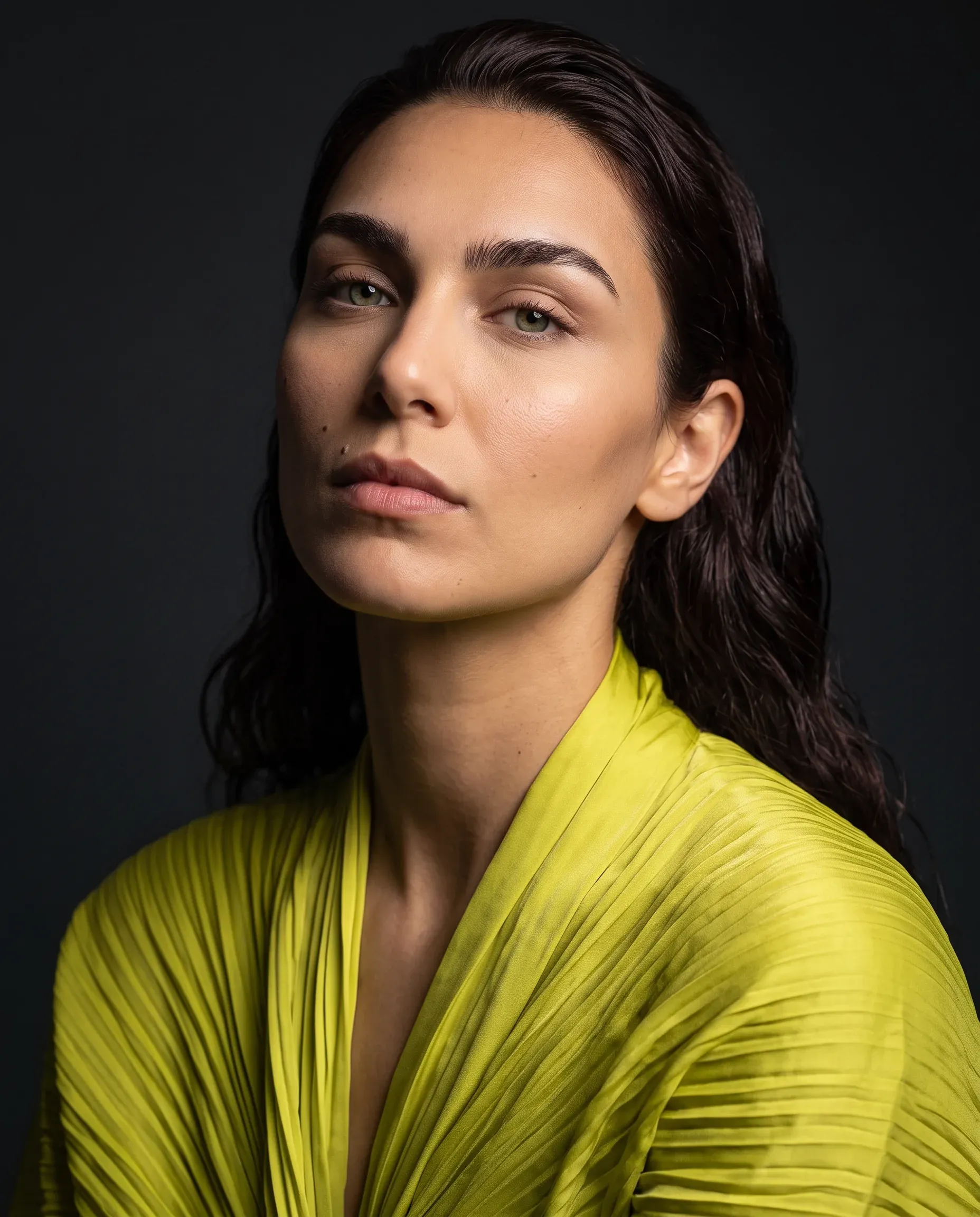 The same character in an editorial portrait wearing an acid-lime silk blouse against a charcoal backdrop